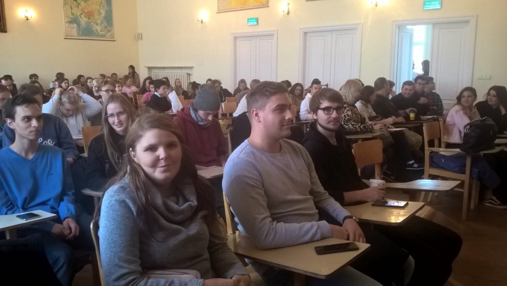 Uczniowie sluchają wykładowcy Uniwersytetu Warszawskiego.
