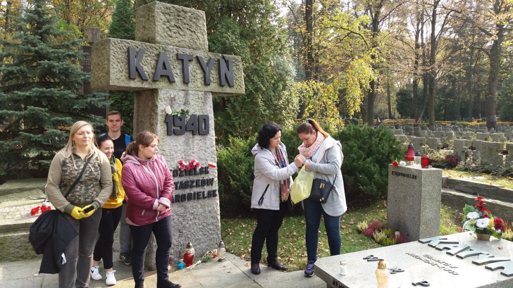 Wolontariusze wraz z opiekunami przy pominku pamięci ofiar zbrodni Katyńskiej .