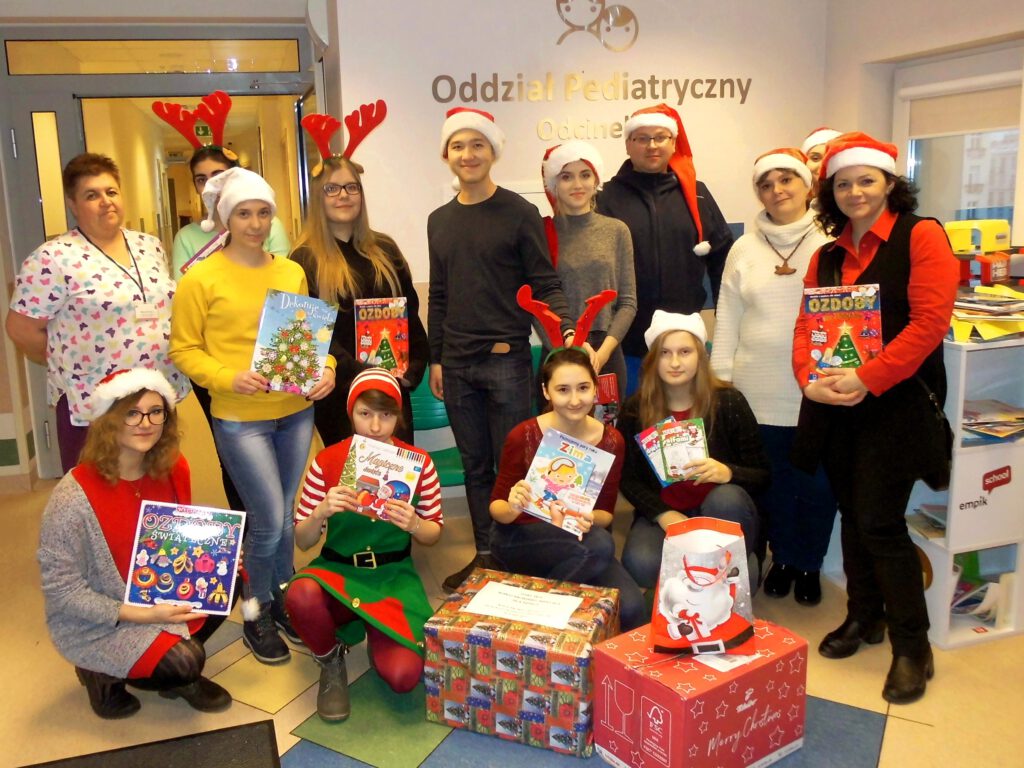 Wolontariusze wraz z opiekunami w szpitalu z ozdobami świątecznymi.