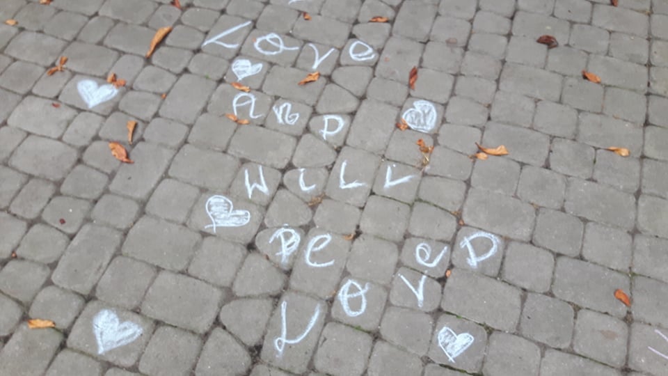 Na chodniku narysowane serduszka i napis "Love and will be loved"