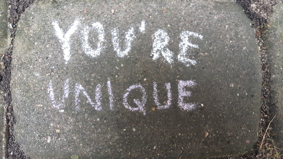 Napis białą kredą na chodniku "You`re unique"