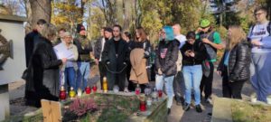 Grupa uczniów stoi przy grobie