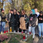 Grupa uczniów stoi przy grobie