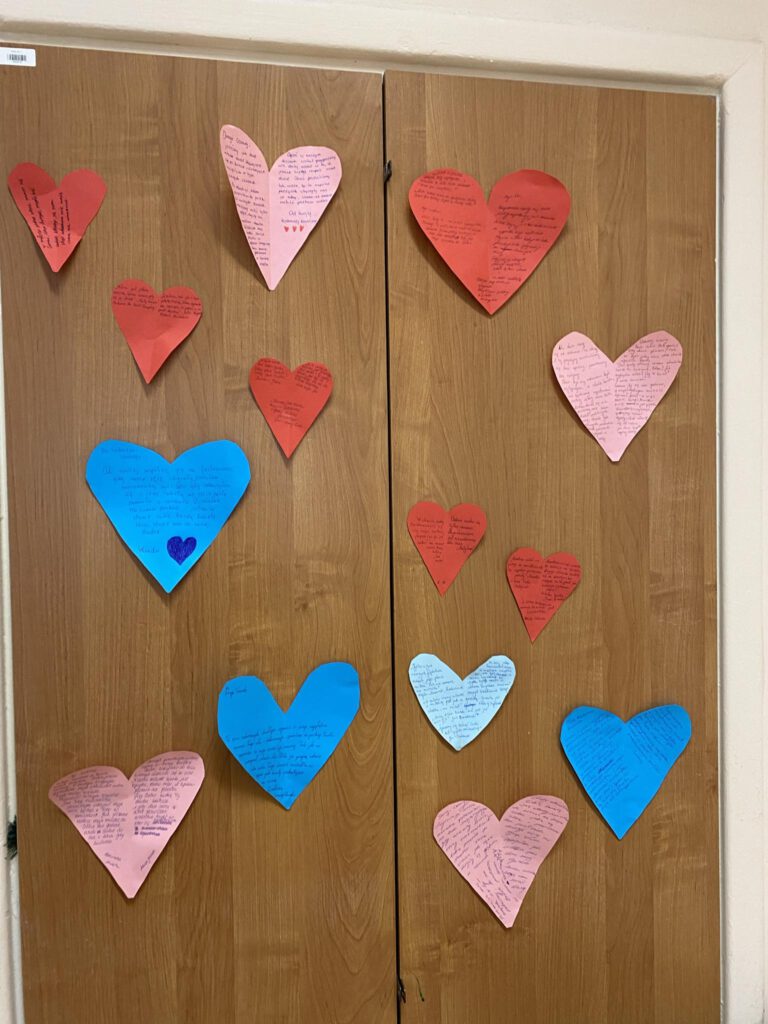 Na drzwiach od szafy wiszą czerwone, różowe i niebieskie , papierowe serduszka z napisami.