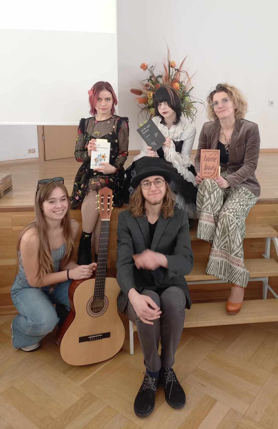 Cztery kobiety i jeden mężczyzna pozują do zdjęcia.Jedna z kobiet trzyma gitarę.
