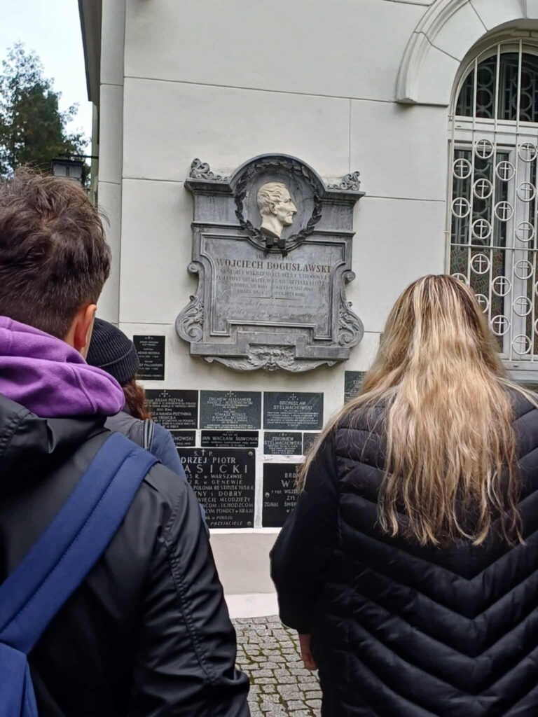 Zdjęcie klasy przy tablicy upamiętniającej Wojciecha Bogusławskiego.