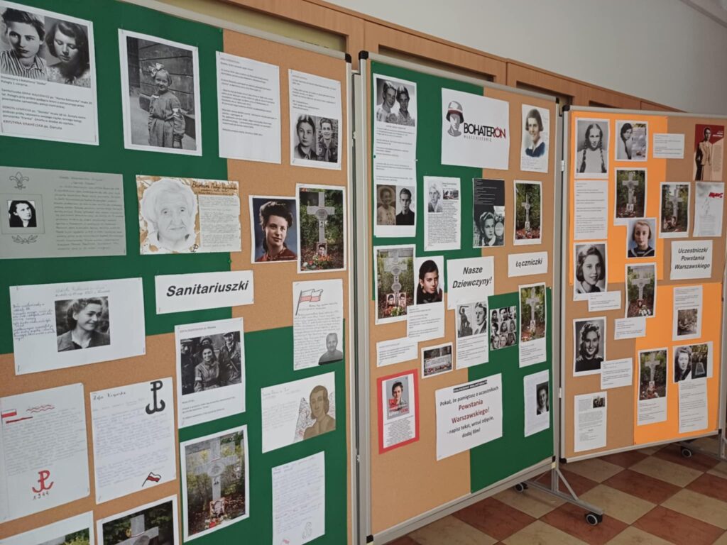 Zdjęcie przedstawia wystawę przygotowaną w ramach akcji BohaterON. Na środkowej tablicy znajduje się napisy "Nasze dziewczyny" oraz "Łączniczki", którym akompaniują zdjęcia i opisy. Na lewej tablicy po środku znajduje się napis "Sanitariuszki", również otoczony zdjęciami i opisami. Na prawej tablicy znajduje się napis "Uczestniczki Powstania Warszawskiego" wraz ze zdjęciami i opisami.