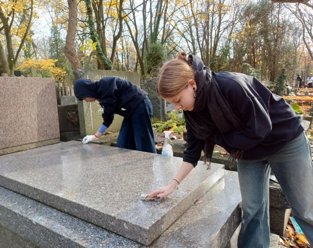 Zdjęcie uczniów sprzątających grób Bohdana Frańczuka.